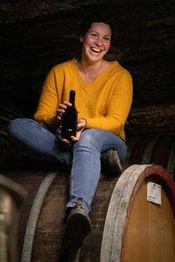 Madeleine Ries sitzt auf einem Weinfass und freut sich auf den Winetalk.